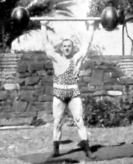 Old school strong man Herman Goerner demonstrating the overhead press.  Good exercise form, terrible fashion choice.