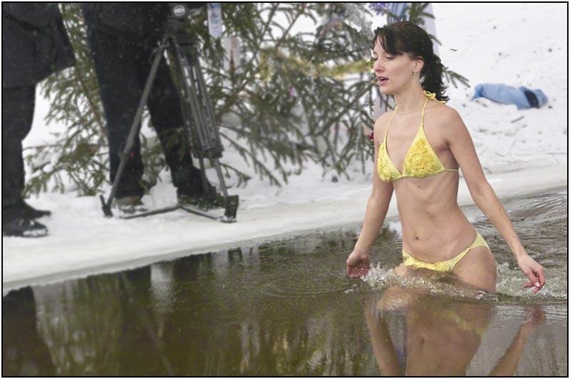 Woman diving in an icy lake during a winter celebration