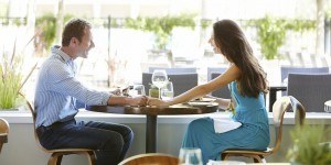 Couple Holding Hands At Outdoor Restaurant Table