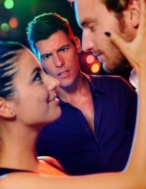 Desperate jealous man looking at flirting couple in discotheque.