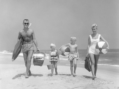 d-corson-1950s-family-of-four-walking-towards-camera-with-beach-balls-umbrella-picnic-basket-and-sand-bucket