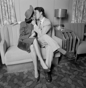 Couple kissing in railroad parlor car (B&W)