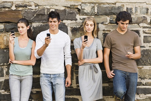 Full length portrait of young men and women holding cellphone