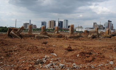 Site ready for construction, with city skyline in background