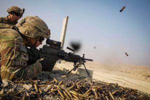 A U.S. soldier from the 3rd Cavalry Regiment is watched as he fires a squad automatic weapon during a training mission near forward operating base Gamberi, in the Laghman province of Afghanistan December 15, 2014. REUTERS/Lucas Jackson (AFGHANISTAN - Tags: CIVIL UNREST MILITARY)